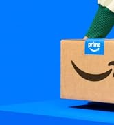 El empaque de Amazon Prime se muestra en un fondo azul brillante, con el distintivo logotipo de Prime Smile en cartón marrón.