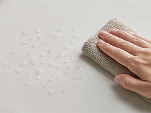 Drücken Sie mit der Hand auf einen hellen Stoff oder eine Oberfläche mit sichtbaren Wassertröpfchen, die wasserabweisende Eigenschaften aufweisen.