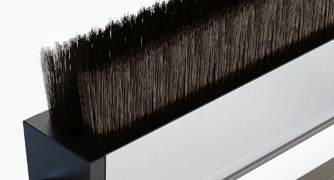 Close-up of a black bristle brush strip mounted on a silver metallic base, showing dense bristles arranged in a straight line.