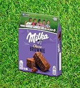 El texto dice «Milka Brownie». El empaque del producto para un bocadillo de brownie de chocolate se muestra sobre un fondo de hierba. Caja de color morado con la marca Milka.