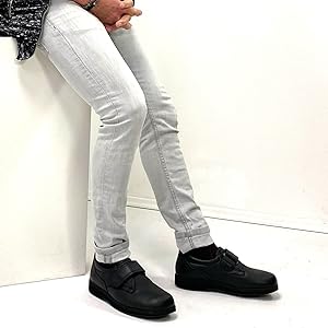 Mann sitzt auf Podest und trägt das schwarze Modell des Natural Feet Klaas XL.