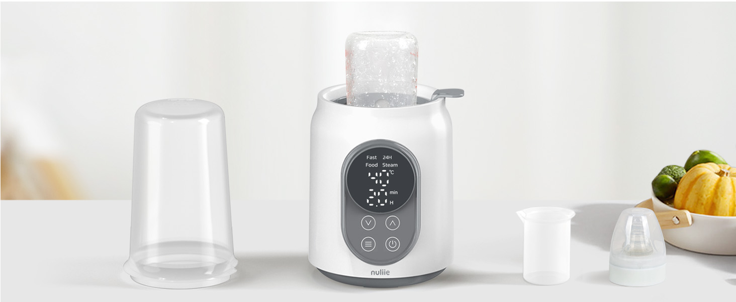 Scaldabiberon bianco con display digitale, accompagnato da contenitore e biberon trasparenti. Impostazione da banco con frutta sullo