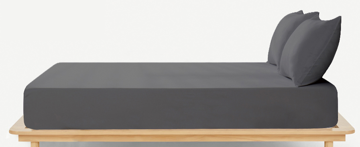 Gray mattress with two matching pillows on a low wooden platform bed frame. The mattress has a minimalist, modern design with clean lines.