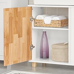 a white bathroom cabinet with a wooden door and a basket of towels.