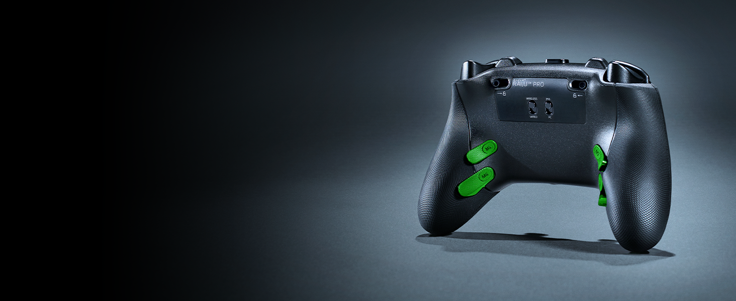 Identical to Image 3: Black gaming controller with green illuminated buttons against dark background with dramatic lighting.