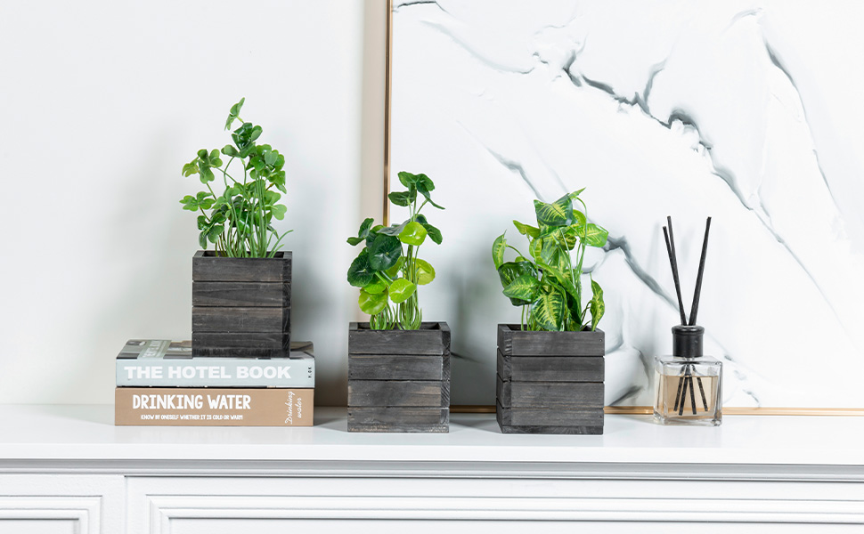 faux plants in grey wooden planter boxes displayed on a mantel