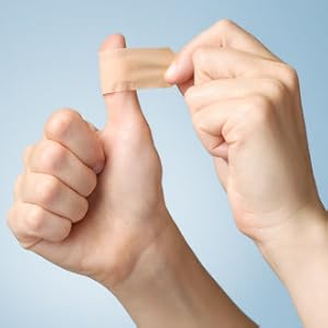 Thumb with bandage being put on it from a first aid kit
