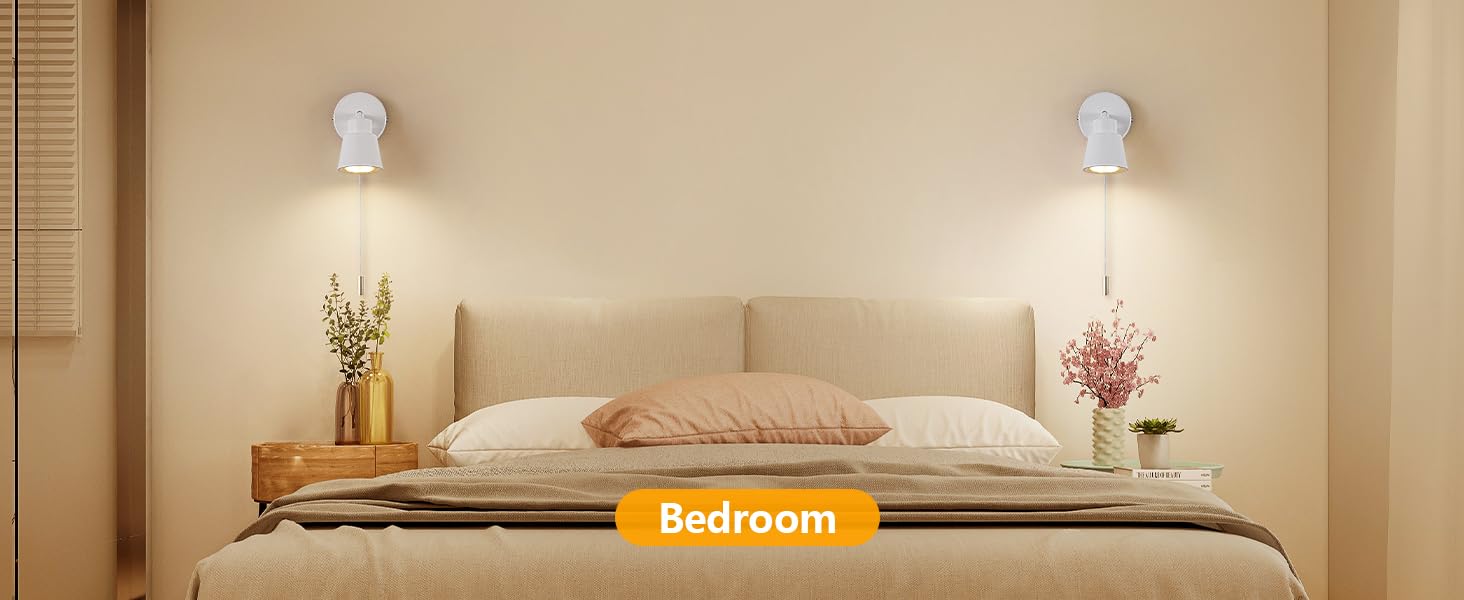 Minimalist bedroom interior with beige bed, white wall sconces, and natural decorative elements including dried flowers