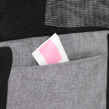 Nahaufnahme einer Tasche oder eines Fachs aus grauem Stoff, in der teilweise ein rosa Gegenstand sichtbar ist.