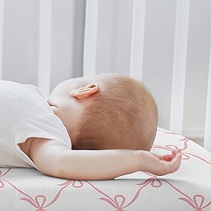 baby laying on crib sheet