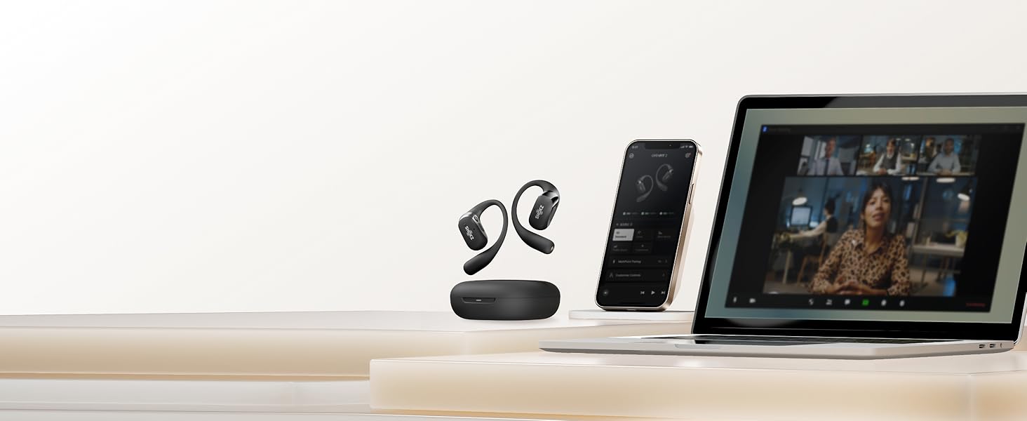 Configuration de l'espace de travail de bureau avec des écouteurs sans fil avec étui de chargement, un smartphone et un ordinateur portable doté d'une interface de lecture vidéo