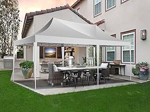 eine Terrasse mit einem weißen Baldachin und einem Tisch und Stühlen.