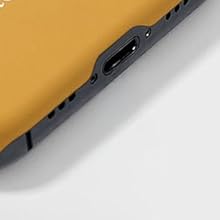 Close-up of a device edge showing a USB-C port. The device has a gold-colored body with a dark gray or black trim around the port.