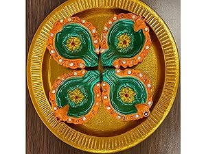 Multiple disposable gold paper plates with emerald green decorative elements arranged on a dark wooden surface, showing identical ornate patterns.