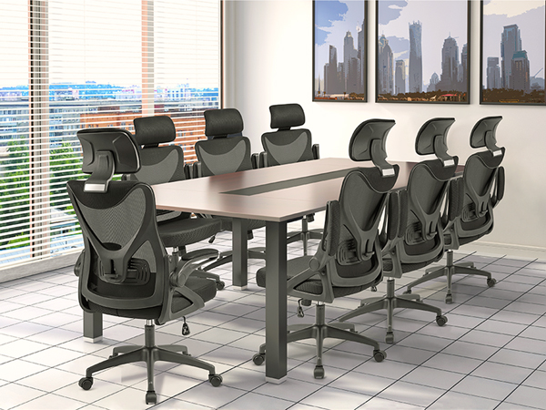 Modern conference room with large table and ergonomic office chairs. City skyline visible through windows. Framed cityscape artwork on wall.