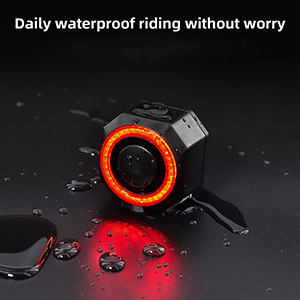 Waterproof bicycle light with glowing red ring. Shown on wet surface with water droplets, demonstrating its waterproof capabilities.