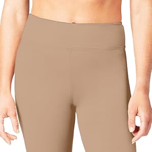 Beige high-waisted seamless leggings or shorts, shown on lower torso and upper legs of a model. Smooth, form-fitting fabric.