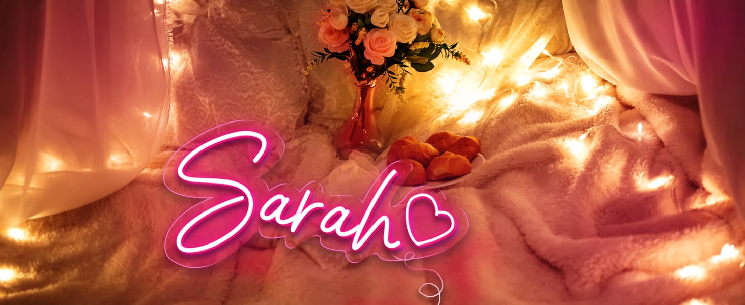 El texto dice «Sarah» en escritura rosa brillante de estilo neón sobre un fondo cálido y dramático con siluetas de ramas de árboles.