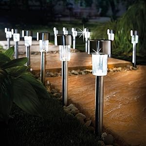 Ambient lighting lifestyle image of solar panel lights along pathway at night in garden