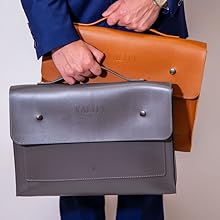 Male carrying two laptop bags one tan and the other grey