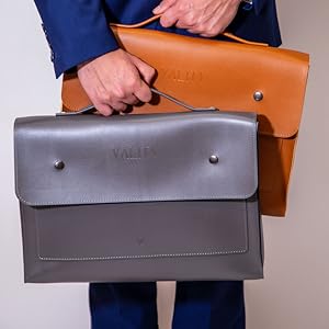 Male carrying two laptop bags one tan and the other grey