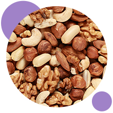 Image circulaire d'un mélange de noix, y compris des noix de cajou, des amandes et des noisettes. Des accents violets encadrent l'image.