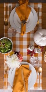 A table set with a DII Pumpkin Spice Heavyweight Check Fringed Table Runner, 14x72&#34;