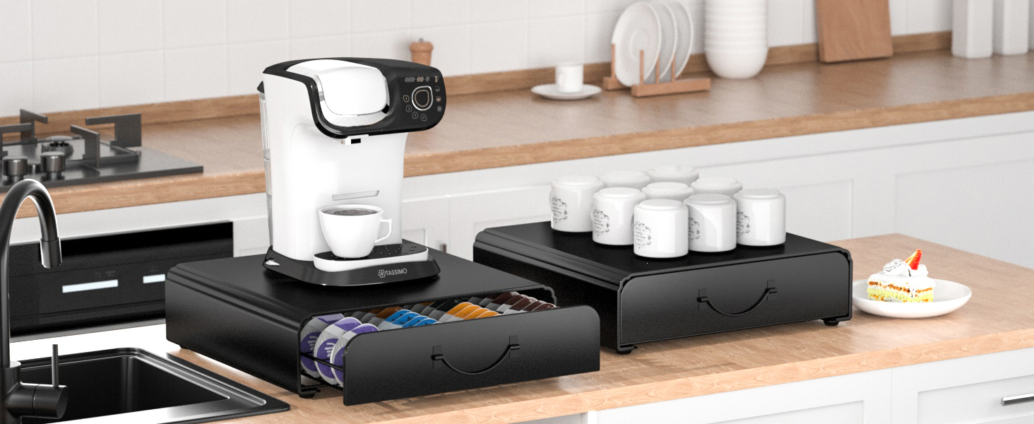 White coffee maker on black drawer organizer system with storage compartments, displayed in modern kitchen setting with wooden countertop.
