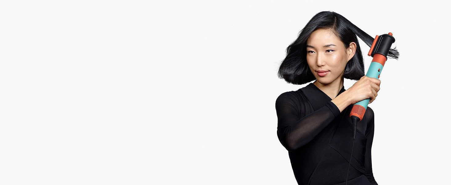 Ein Model mit mittellangem schwarzen Haar nutzt den Trocknungs- und Flyaway-Smoothing-Aufsatz.