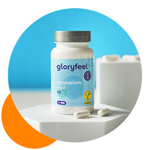 Bouteille blanche de suppléments Glowfeel à côté d'un verre de lait et de gélules en vrac sur fond bleu vif et orange