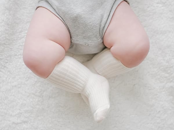 Woolino merino wool baby socks pulled up over chubby baby legs.