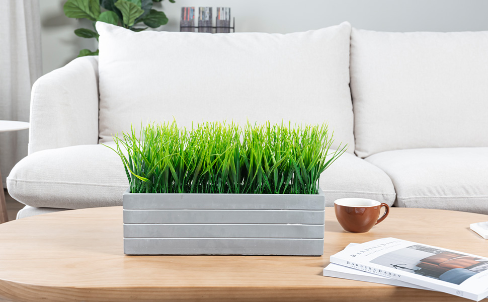 faux grass plant potted in cement planter