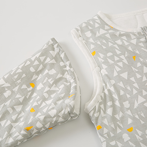 Close-up of white fabric material with small yellow daisy or flower pattern printed throughout.