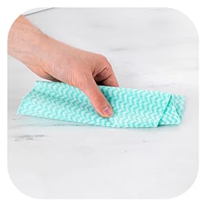 a hand holding a cloth on a marble counter.