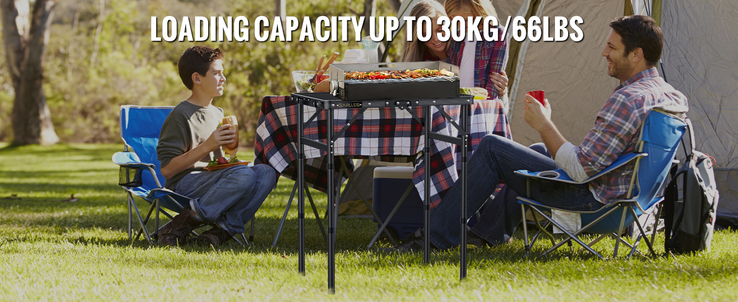 Portable camping table with text indicating 30kg/66lbs loading capacity, shown in outdoor setting with people sitting around it.