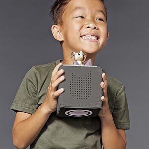 boy holding Toniebox music audio player story telling gray