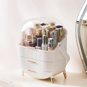 White cosmetic organizer with multiple compartments and drawers. Contains various makeup products and brushes. Curved handle on top.
