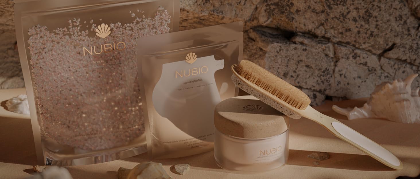 NUBIO foot care products with brush and scrub on sandy surface, accompanied by shells.