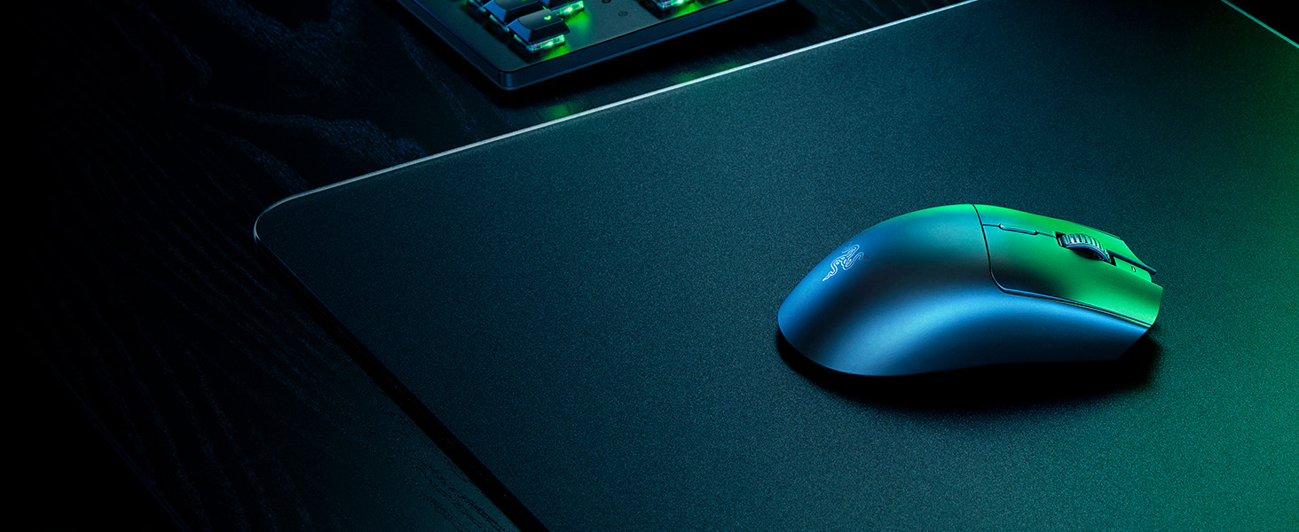 Le texte se lit comme suit : « Image 1 ». Souris de jeu avec des accents verts illuminés sur une surface sombre, capturés dans un éclairage discret spectaculaire créant des effets de lueur bleu-vert.