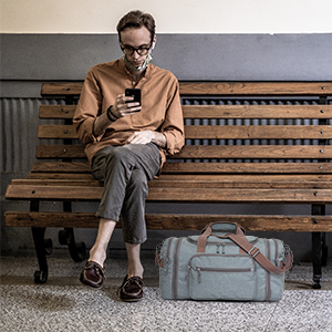 Man sitting on a bench with his nicely packed duffel storage for the overnight weekend stay