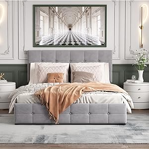 Modern bedroom featuring grey upholstered bed with large hallway perspective artwork above, white nightstands, and peach throw blanket.