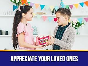 A girl and a boy are laughing while holding a toddler thank you cards.