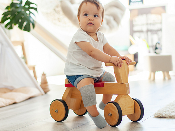 baby riding on hardwood floor