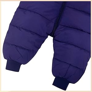 Close-up of deep purple quilted fabric, likely part of a winter garment, with visible stitching and a ribbed cuff at the bottom.