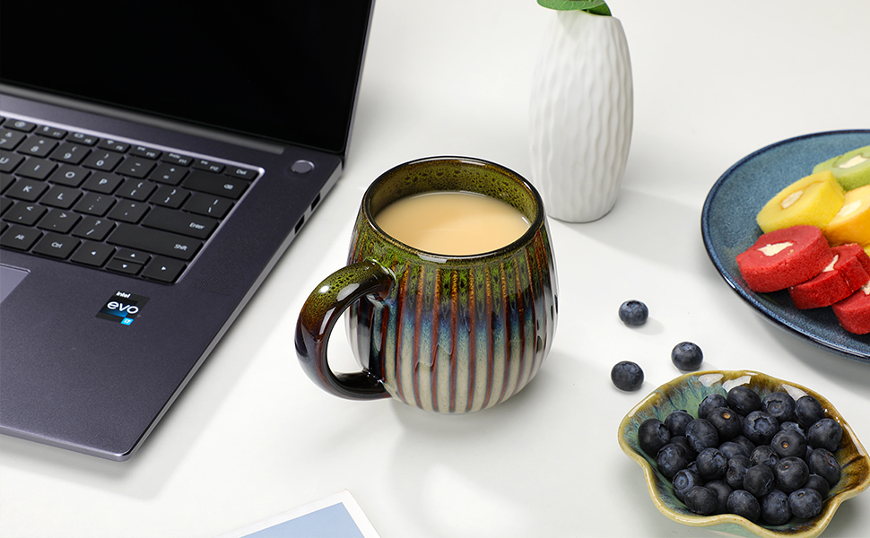 A cup of coffee is placed on the desk, with a notebook and cake next to it