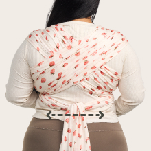 Back of plus-sized parent using baby wrap in a strawberry-patterned print. The wrap fits most.