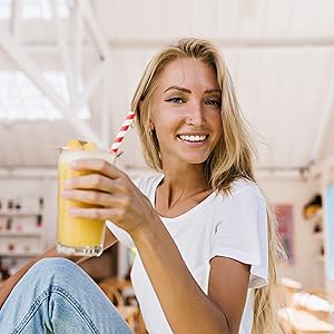 Vrij gezond uitziende vrouw drinkt smoothie en glimlachen bij camera