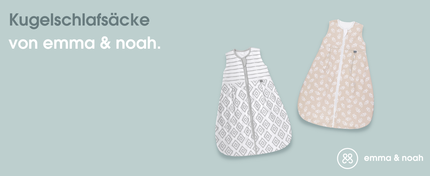 a baby wearing a white and grey bib next to a grey and white striped blanket.