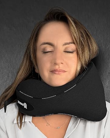 Black travel neck pillow in use, providing head and neck support against dark background.