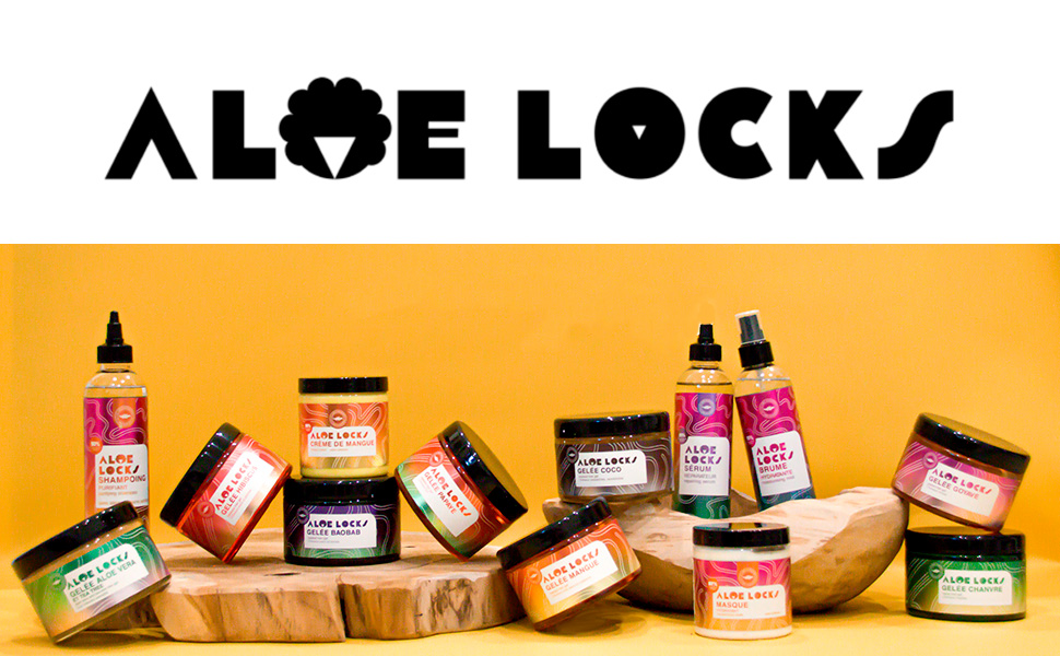 Collection de produits de soins capillaires colorés présentés sur des dalles de bois. Comprend des bocaux, des bouteilles et des contenants de différentes tailles. Texte « ALOE LOCKS » visible au-dessus